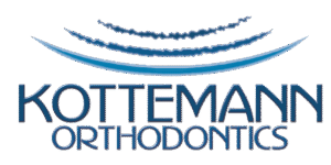 Logo for Kottemann Orthodontics with blue waves above and below the text on a black background.